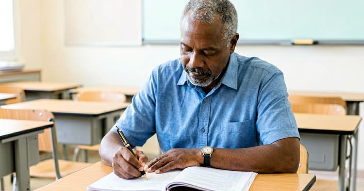 Teacher marking exercise books in the classroom