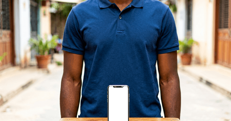 Young Mozambican man in a street courtyard making a mobile transaction with a smartphone