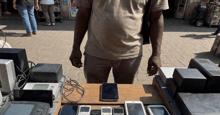 Mozambican female seller in a street market in Maputo with a mobile phone