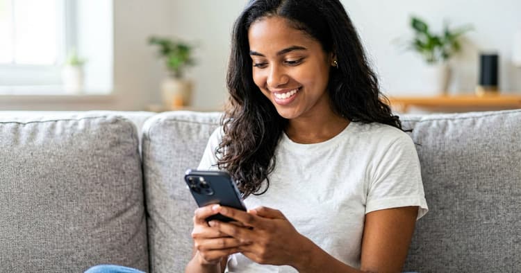 Young person writing a CV on a mobile phone at home