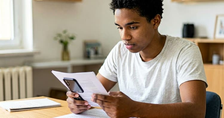 Young person writing their resume on a mobile phone at home