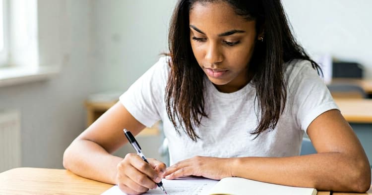 Young person writing their CV profile by hand