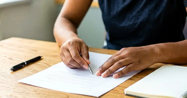 Mãos a preparar o modelo de CV em papel
