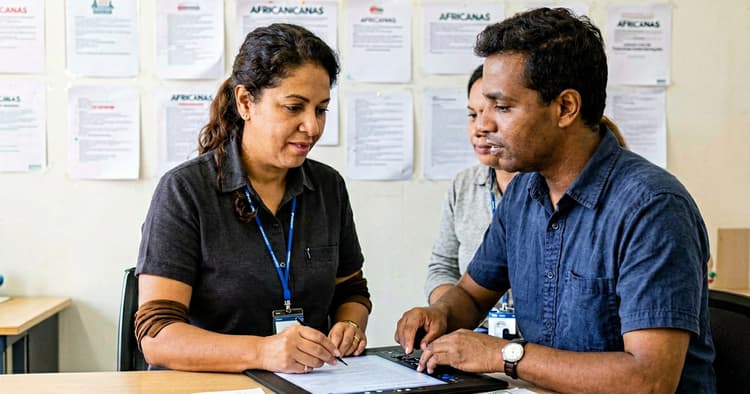 Mozambican tech professionals discussing a project in front of a laptop