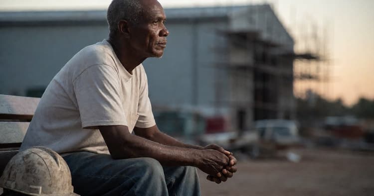 Thoughtful dark-skinned Mozambican worker at a construction site, considering their disciplinary defense