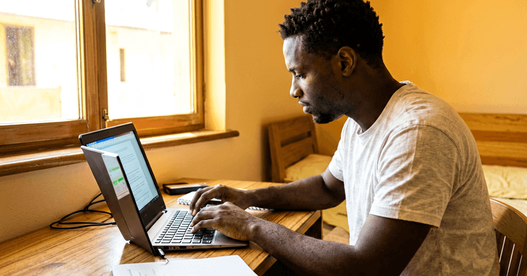 Young Mozambican editing a modern CV template on a laptop