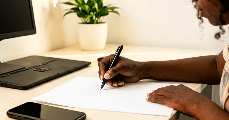 Blank sheet of paper and closed laptop on a desk before writing a modern CV in Word