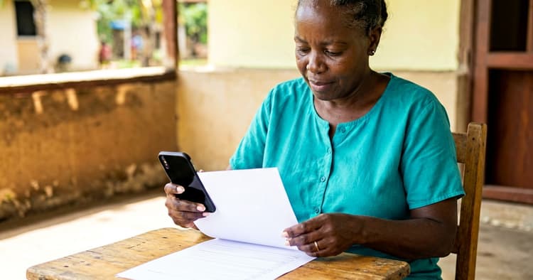 Mozambican female worker sending CV in PDF via WhatsApp on mobile phone