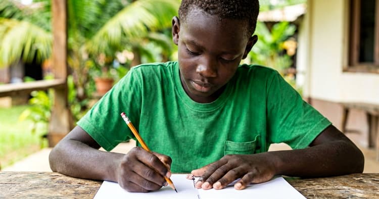 young apprentice writing a CV objective in a blank notebook