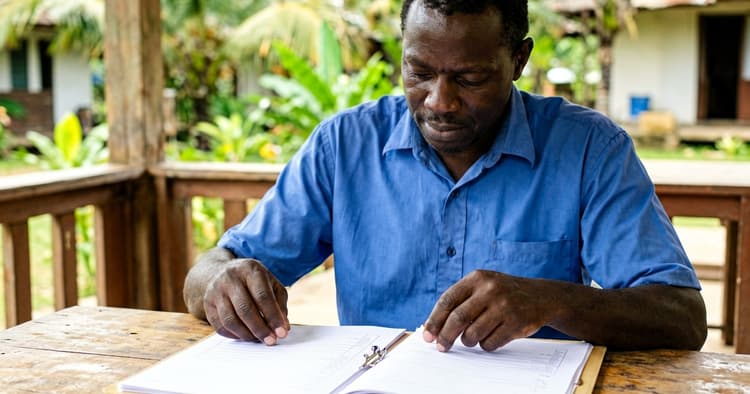 Mozambican worker organising an application folder with CV and certificates