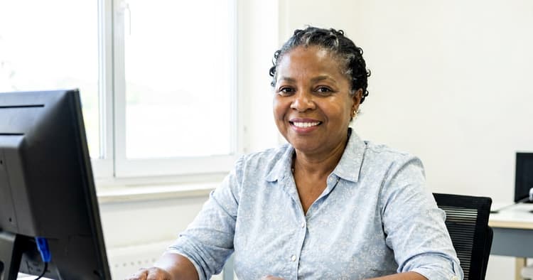 Mozambican woman preparing a CV with AI on a laptop with the screen off