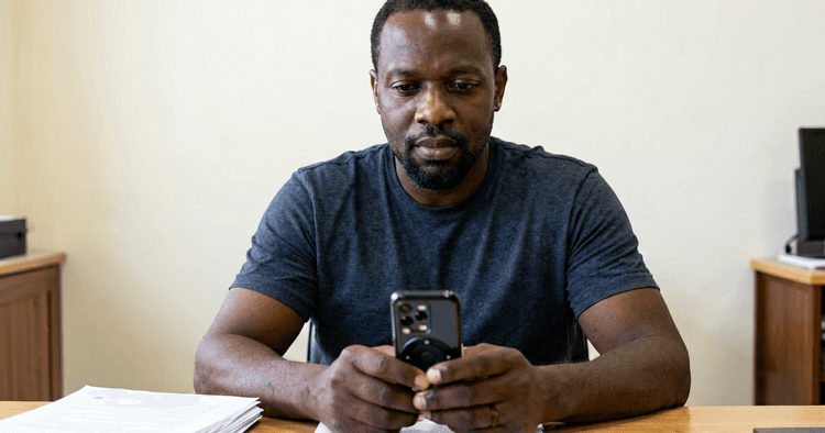mature Mozambican worker reviewing retirement plan with consultant, office facing away from window