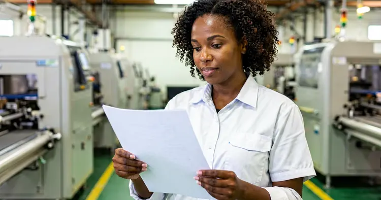 Mozambican factory worker recording night work hours on a daily timesheet