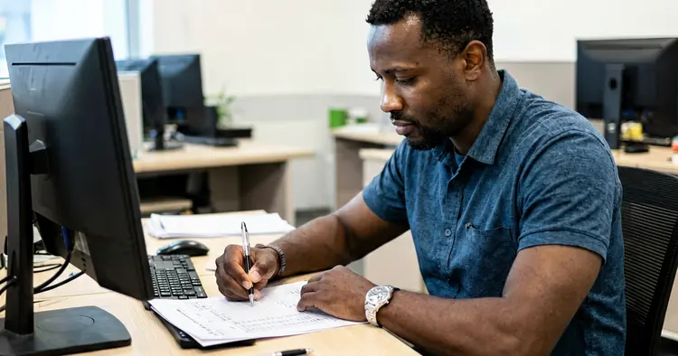 office worker in Maputo calculating salary with overtime