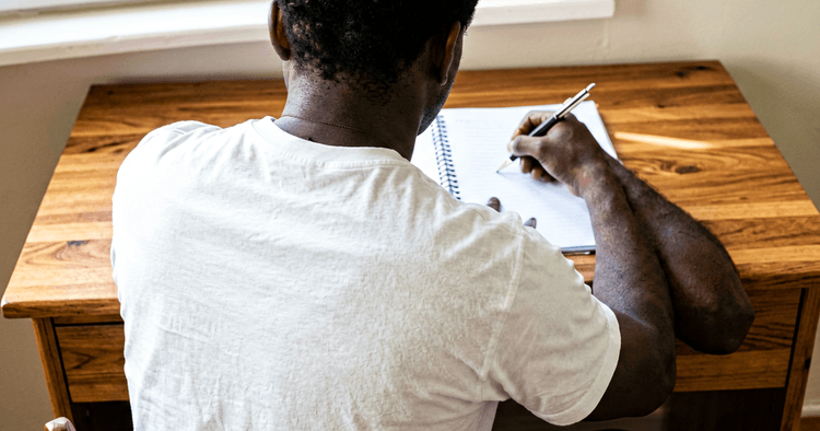 Mozambican candidate updating their CV at home, computer seen from behind
