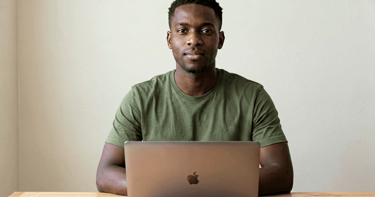 Young Mozambican working at home with a closed laptop preparing an application